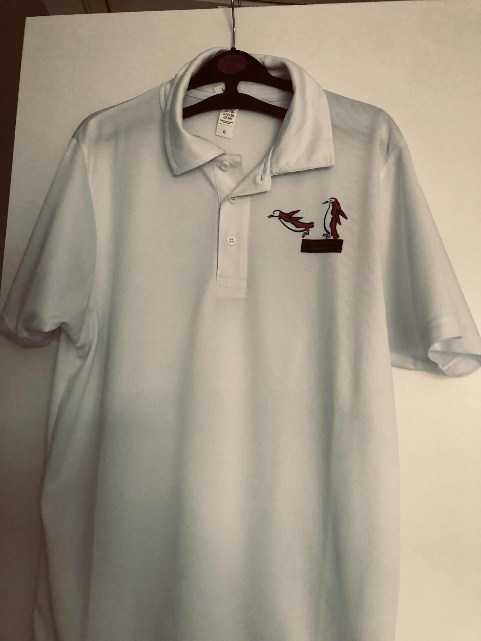 White cool polo for timekeepers with black dive board penguins logo on right breast